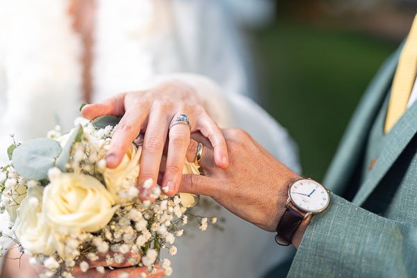 Photo de composition avec bouquet, alliances et montre