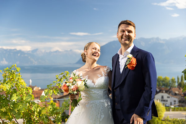 Les mariés rigolent dans les vignes sous le ciel bleu de Cully