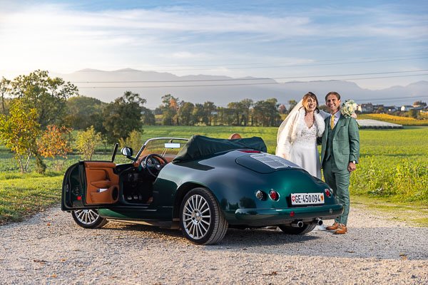 Les mariés avec une belle voiture d'époque dans la campagne genevoise
